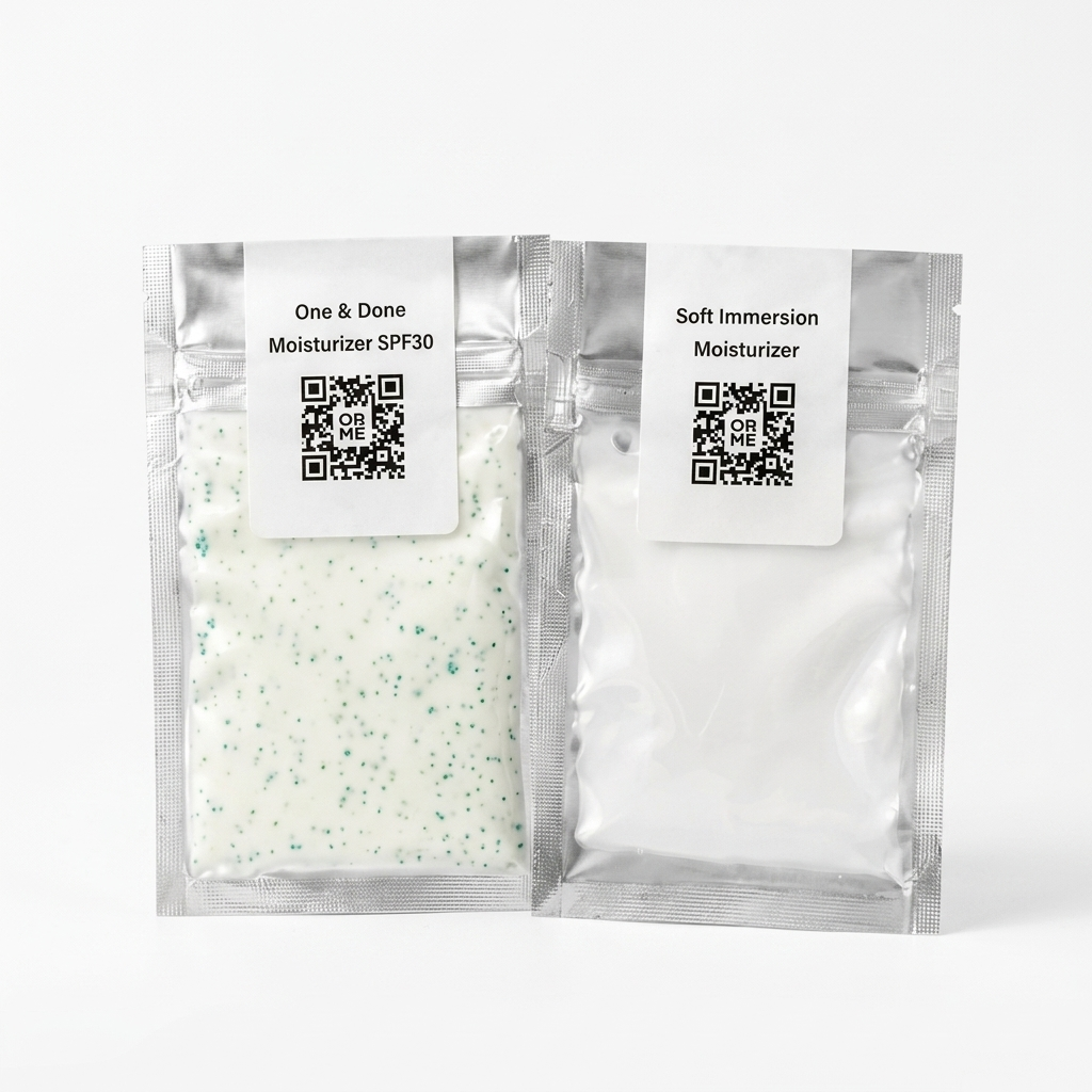 Two silver resealable pouches of moisturizer on a white background. The left pouch is labeled 'One & Done Moisturizer SPF30' and contains a white moisturizer with green speckles.