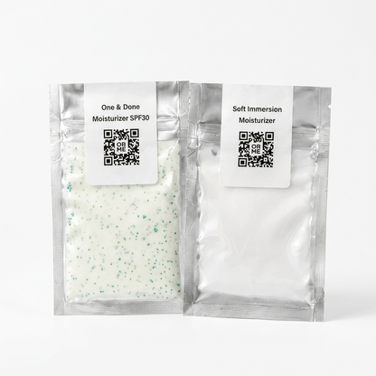 Two silver resealable pouches of moisturizer on a white background. The left pouch is labeled 'One & Done Moisturizer SPF30' and contains a white moisturizer with green speckles.